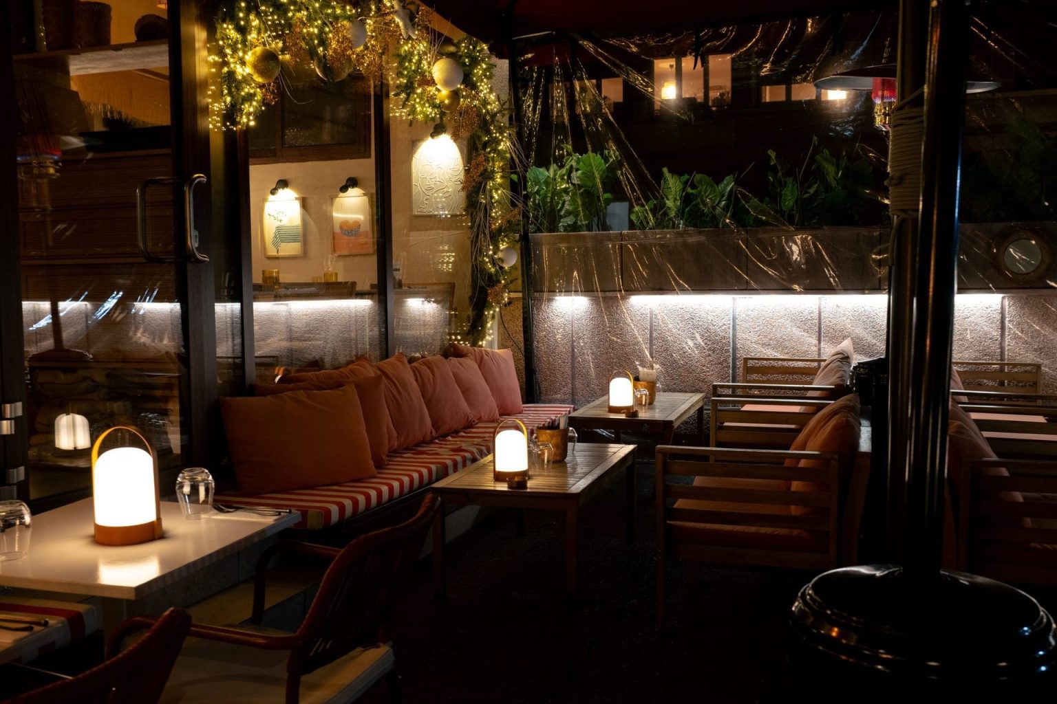 Salon de la terrasse de La Pagaille avec banquettes et lampes, privatisable pour un anniversaire ou une soirée